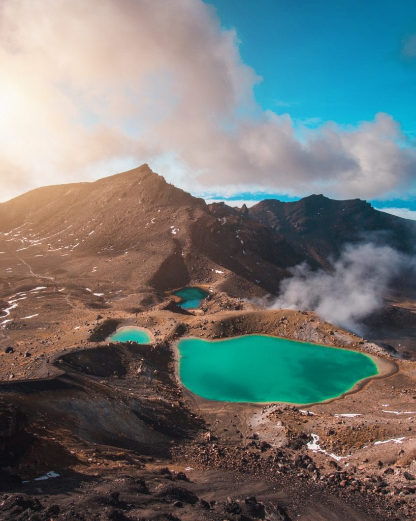 View across the Tongariro Alpine Crossing looking towards mountains and over the blue lagoons