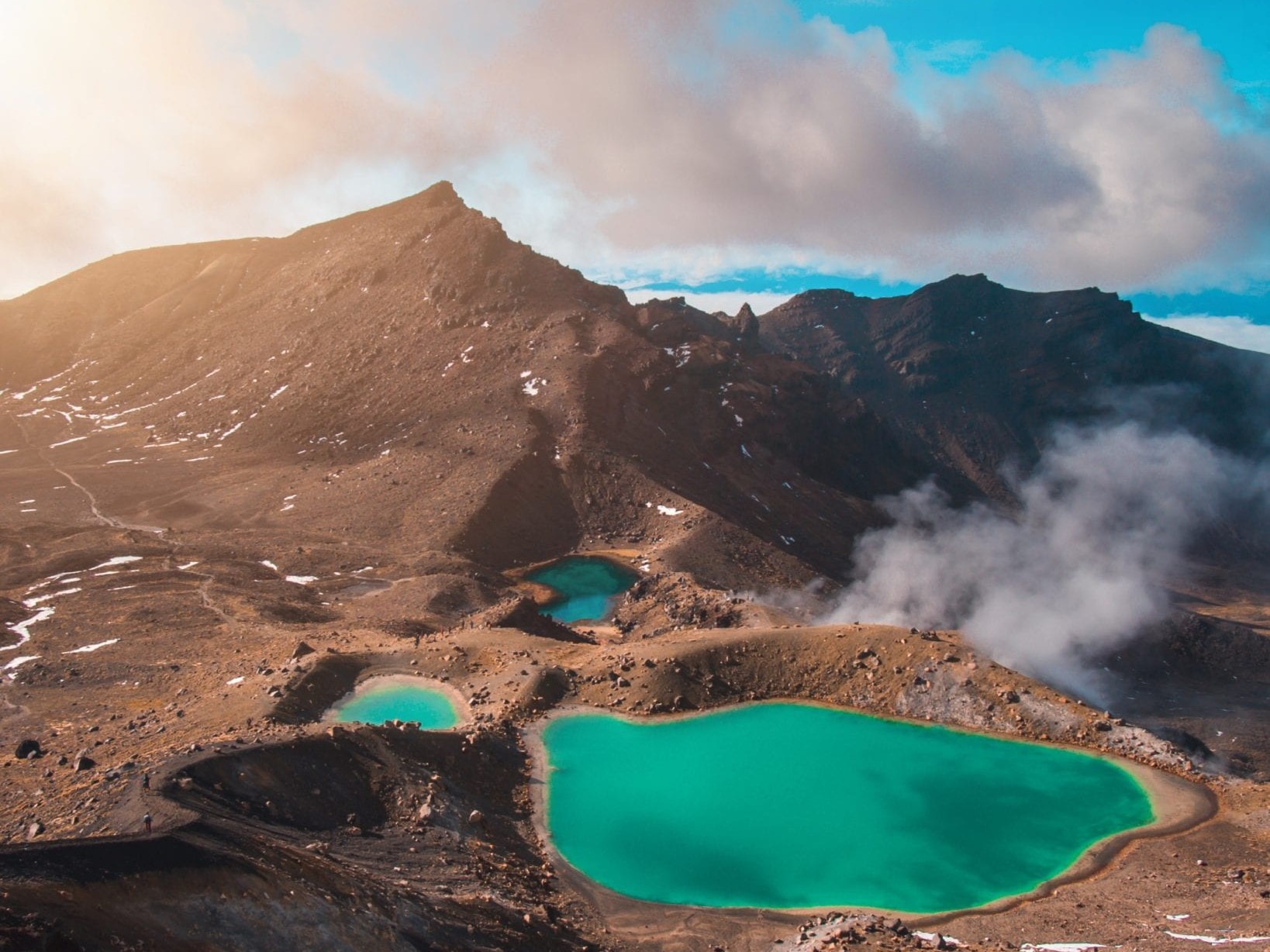 View across the Tongariro Alpine Crossing looking towards mountains and over the blue lagoons