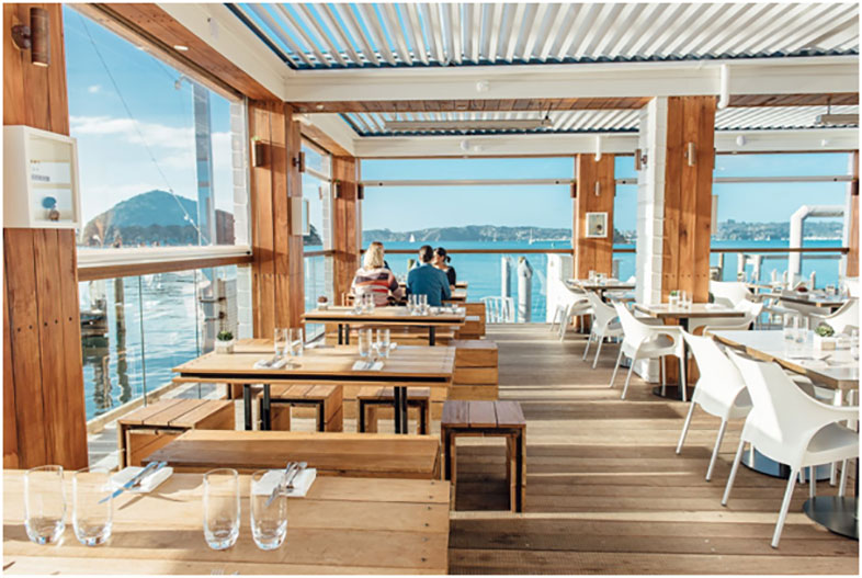 Interior view of Charlotte's Kitchen restaurant with sea and mountains in background